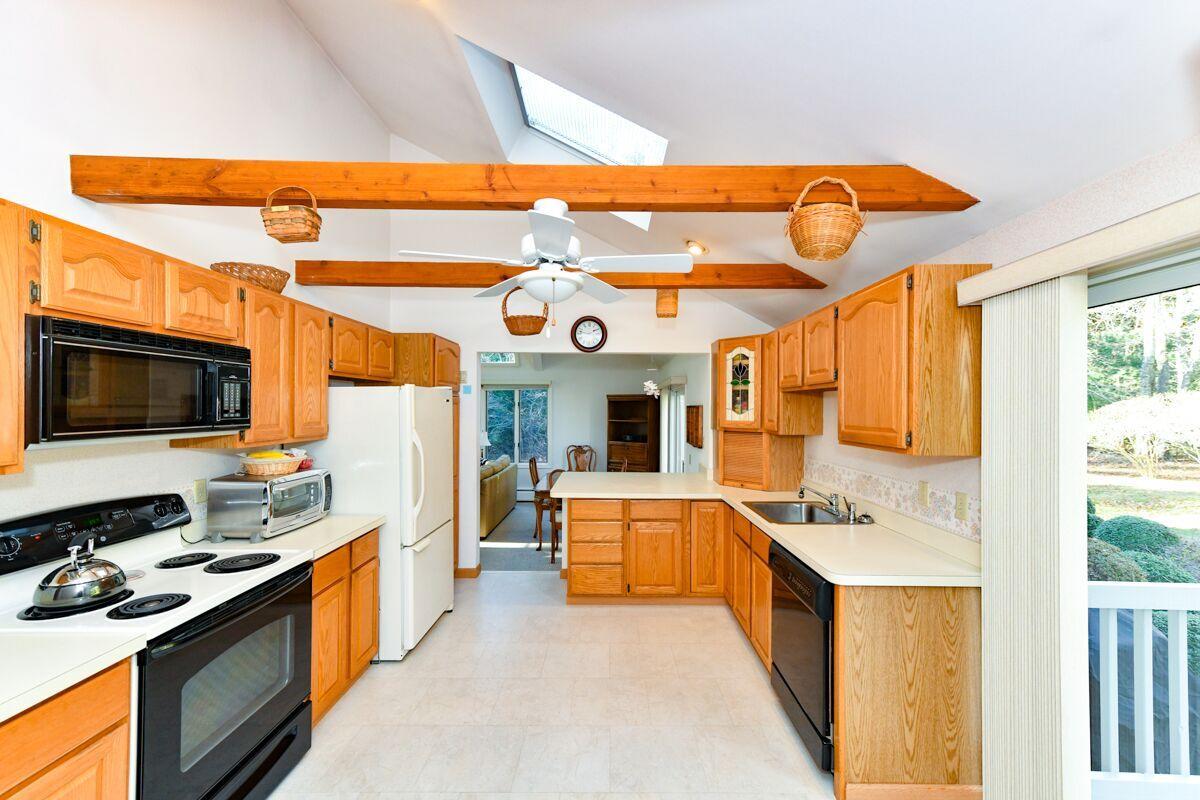 254 Cedric Road Centerville, MA 02632 - Photo 3 of 24 a large kitchen with stainless steel appliances granite countertop a stove and a microwave
