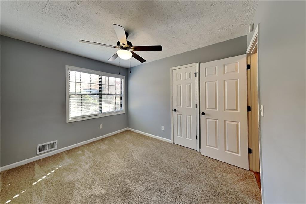 4304 Falcon Crest Drive Flowery Branch, GA 30542 - Photo 14 of 21 an empty room with windows and fan