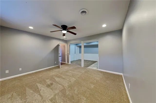 a view of an empty room with a ceiling fan