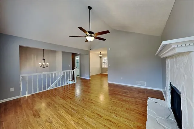 a view of room with wooden floor a ceiling fan and a window