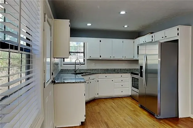 a kitchen with a refrigerator sink and cabinets