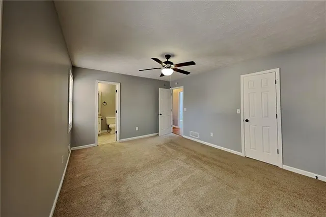 a view of an empty room with a ceiling fan