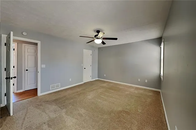 an empty room with fan and entrance