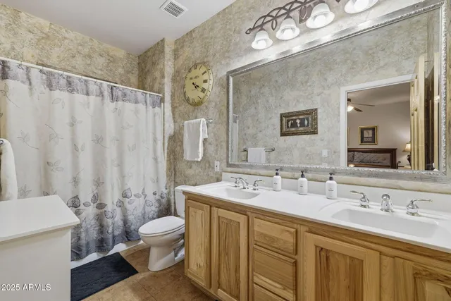 a bathroom with a double vanity sink mirror and toilet