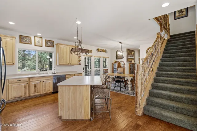 a kitchen with kitchen island granite countertop a stove and a wooden floors