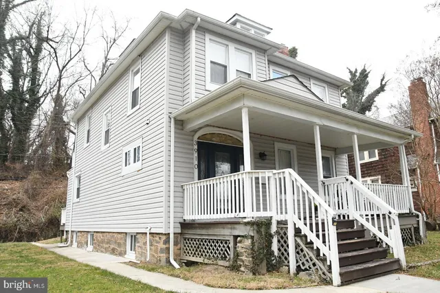 a view of a house with a small yard and wooden fence