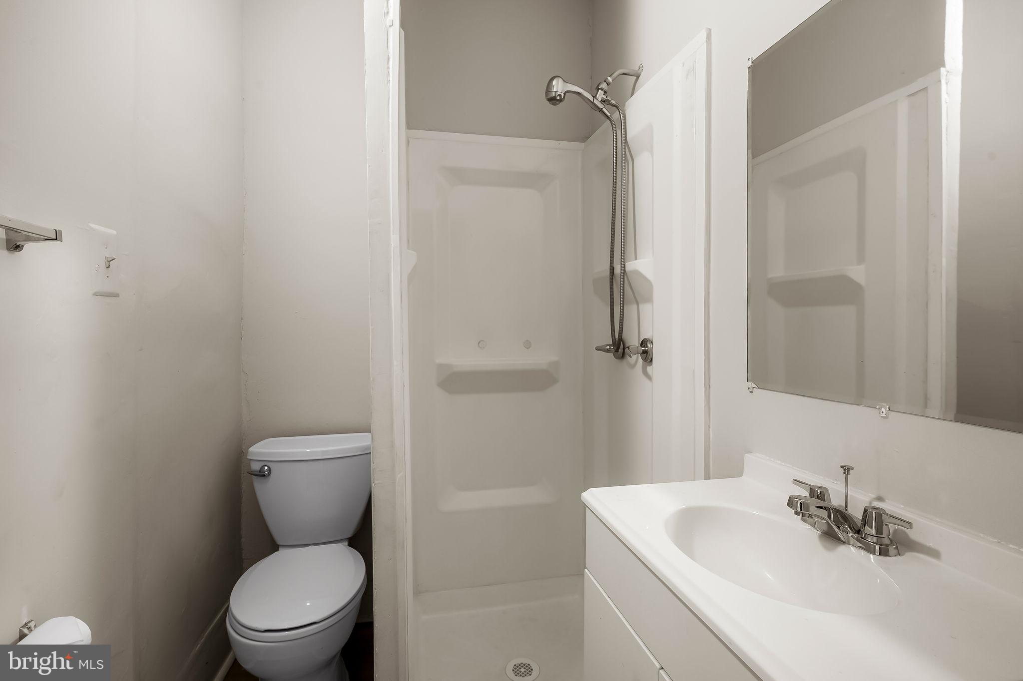 3021 Belair Road Baltimore, MD 21213 - Photo 13 of 27 a bathroom with a toilet sink vanity and shower