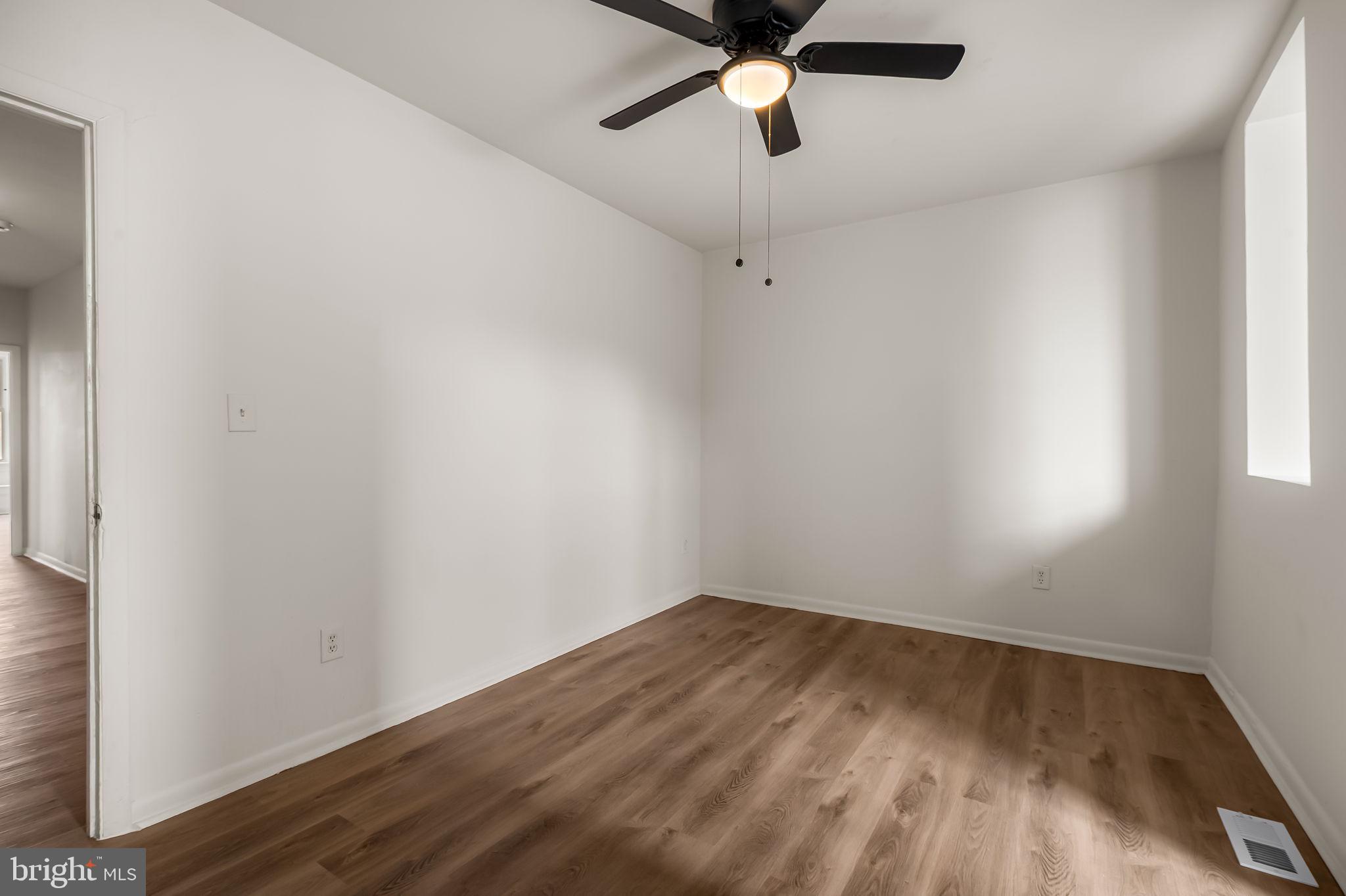 3021 Belair Road Baltimore, MD 21213 - Photo 16 of 27 an empty room with a window and a fan