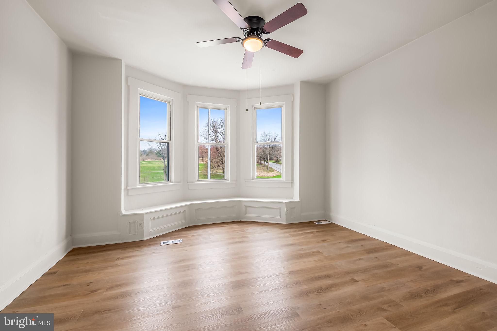 3021 Belair Road Baltimore, MD 21213 - Photo 21 of 27 an empty room with wooden floor and windows