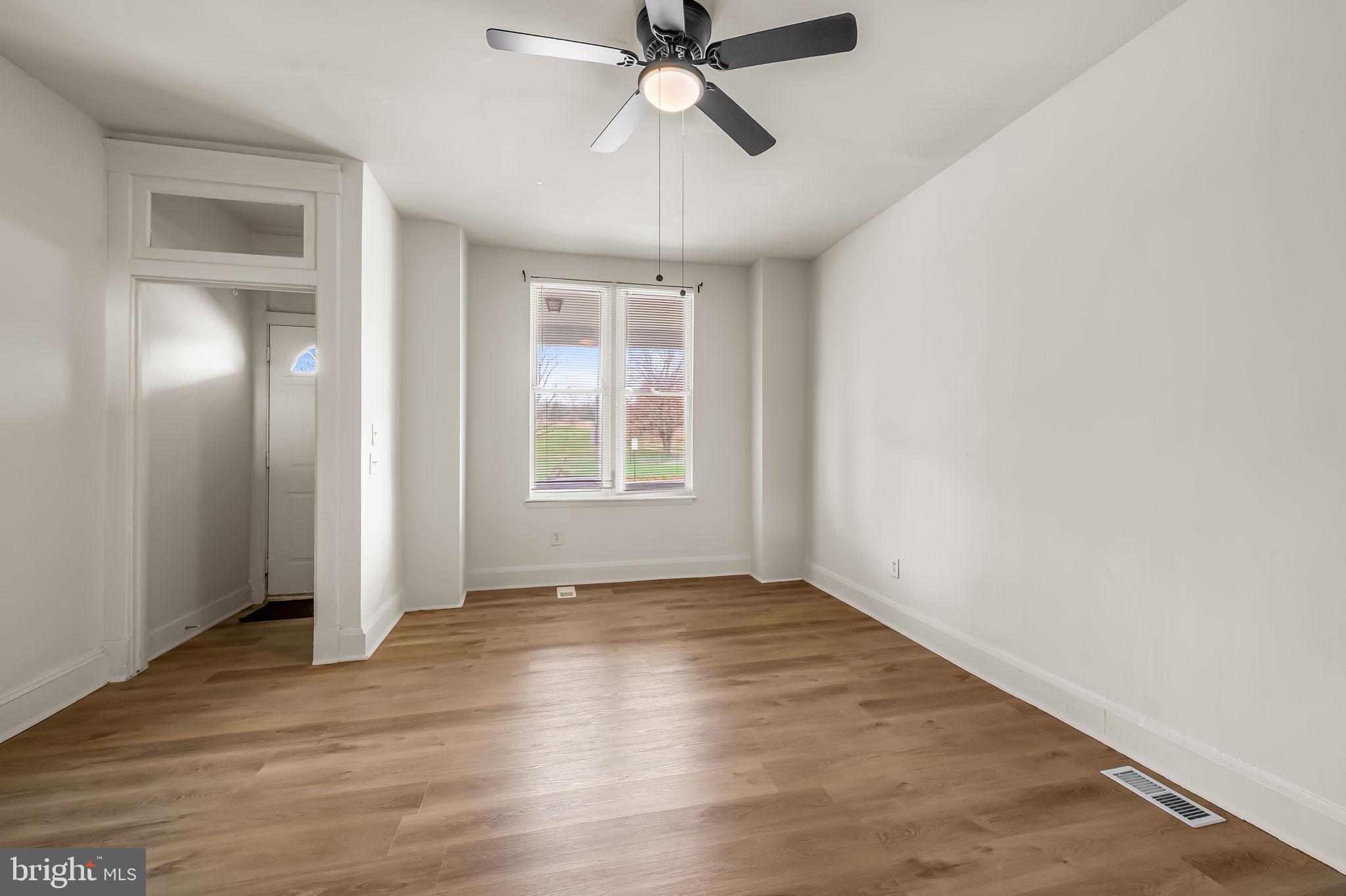 3021 Belair Road Baltimore, MD 21213 - Photo 5 of 27 wooden floor in an empty room with a window