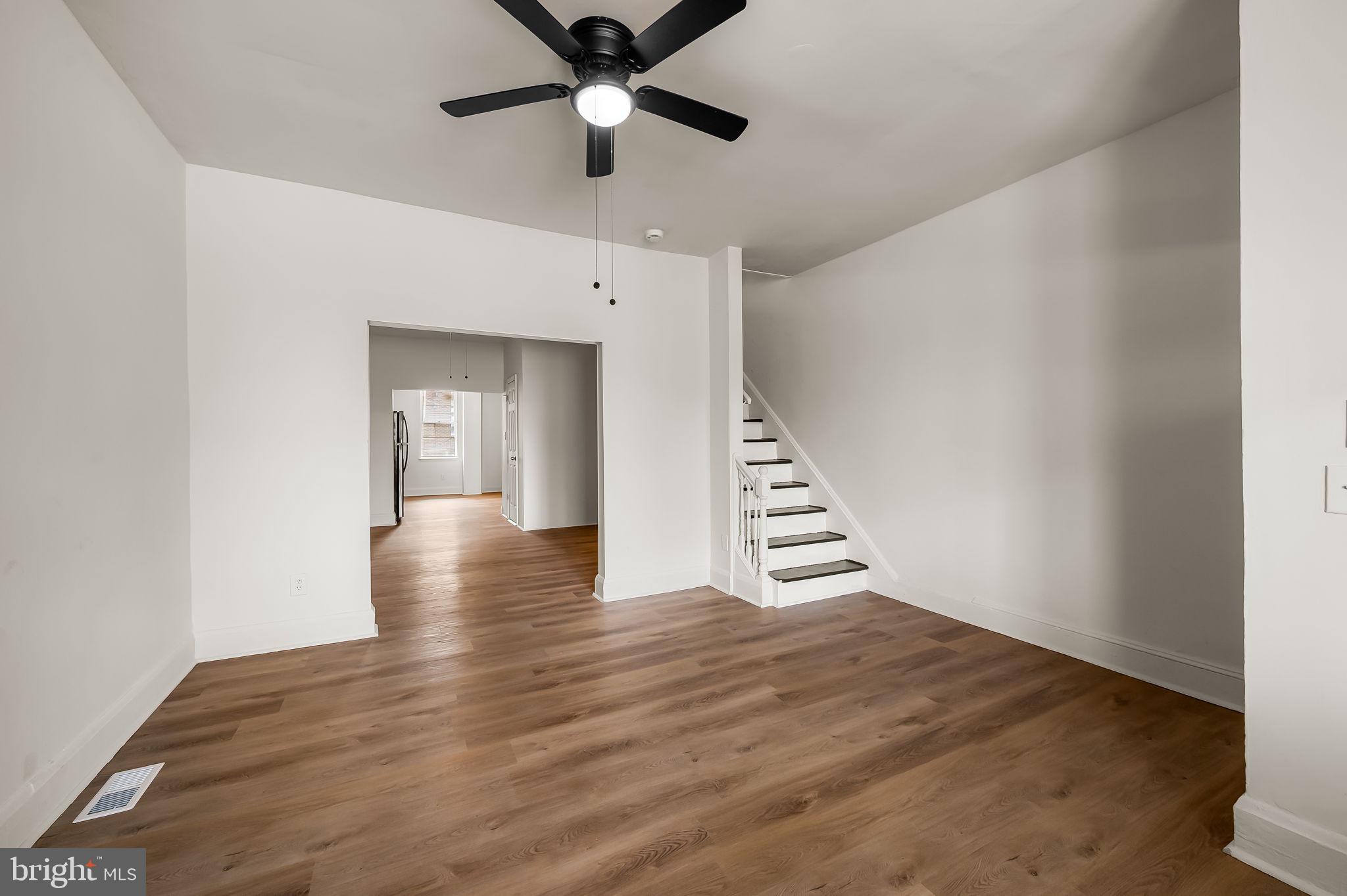 3021 Belair Road Baltimore, MD 21213 - Photo 6 of 27 wooden floor in an empty room with a chandelier fan
