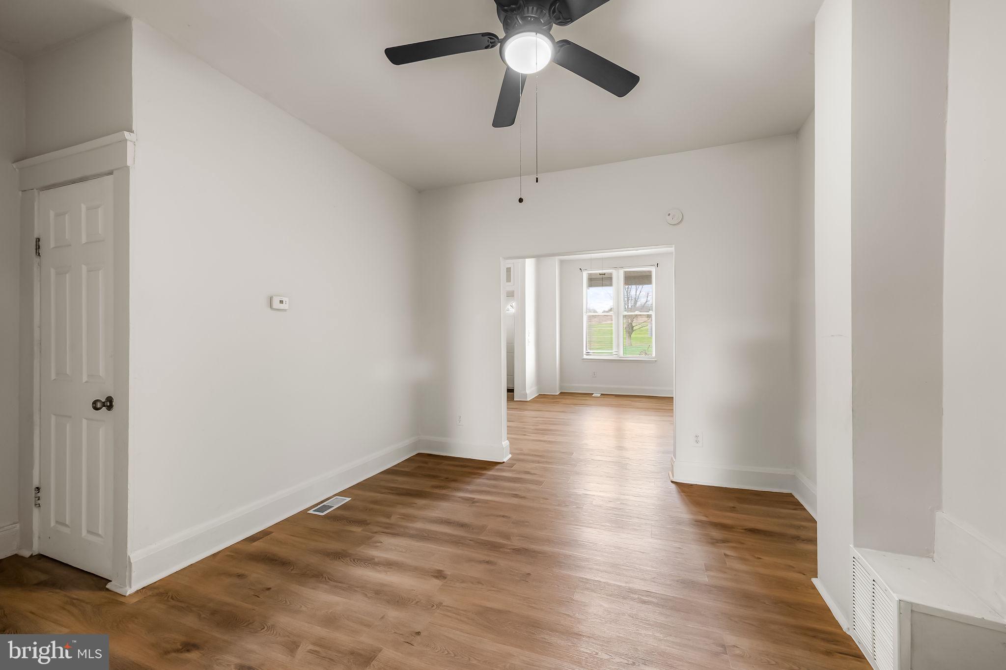 3021 Belair Road Baltimore, MD 21213 - Photo 7 of 27 a view of an empty room with window and wooden floor