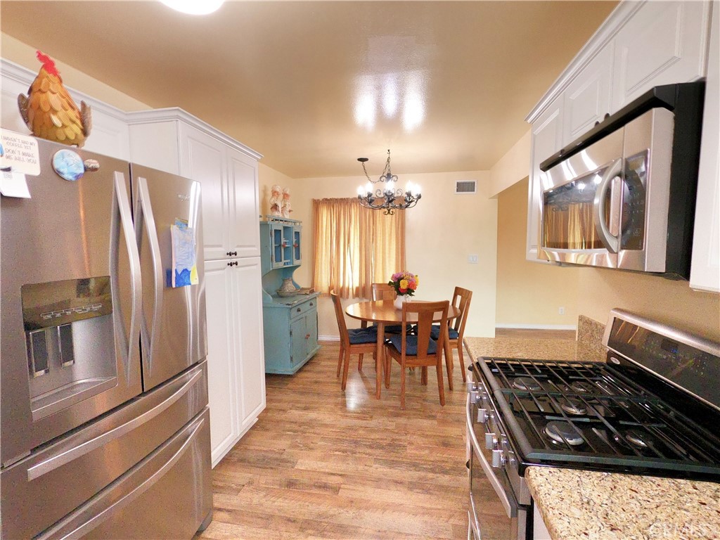 4757 Dundee Road Riverside, CA 92503 - Photo 11 of 26 a kitchen with stainless steel appliances a stove a refrigerator and a dining table