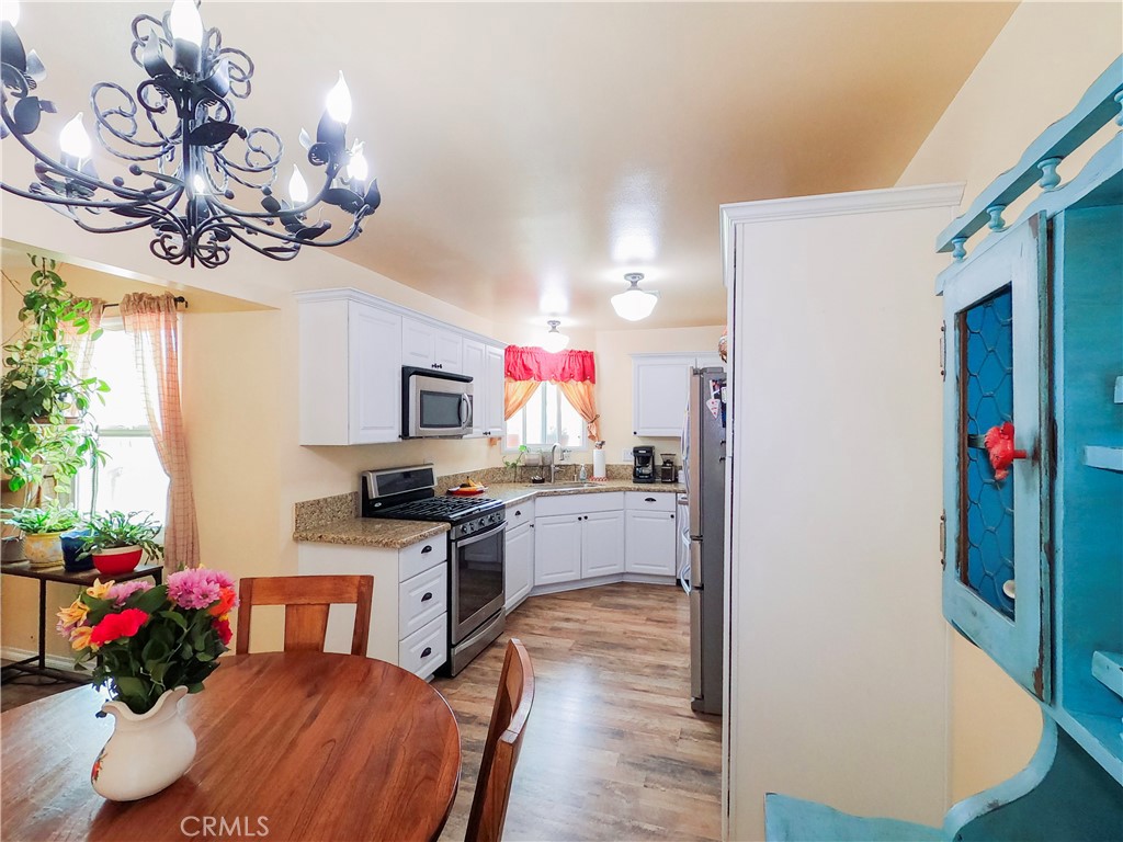4757 Dundee Road Riverside, CA 92503 - Photo 12 of 26 a kitchen with a chandelier stainless steel appliances cabinets and a counter top space