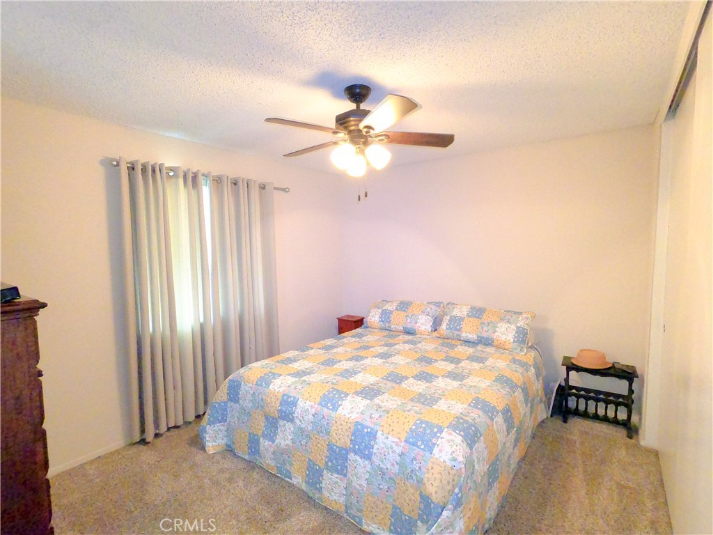 4757 Dundee Road Riverside, CA 92503 - Photo 14 of 26 a bedroom with a bed and a chandelier