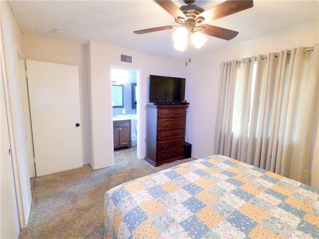 4757 Dundee Road Riverside, CA 92503 - Photo 15 of 26 a bedroom with a bed and a flat screen tv