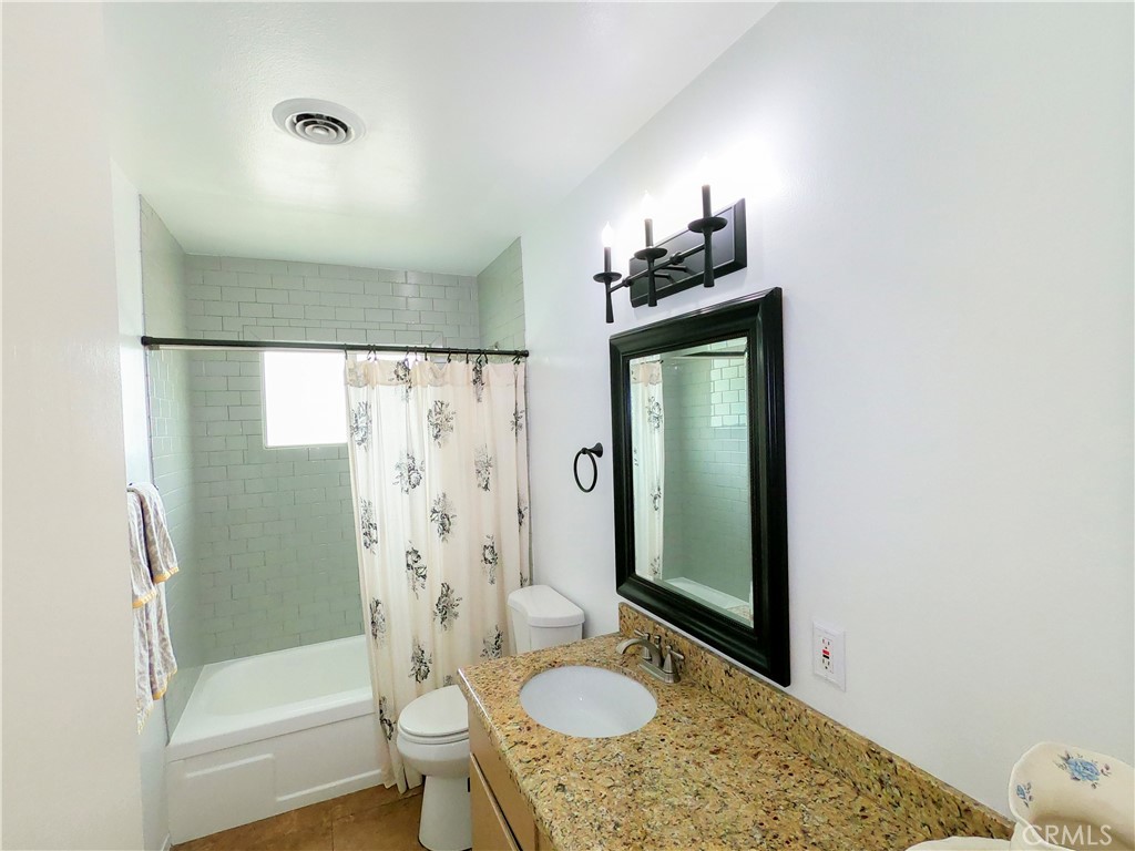 4757 Dundee Road Riverside, CA 92503 - Photo 20 of 26 a bathroom with a granite countertop sink toilet and shower