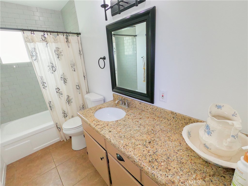 4757 Dundee Road Riverside, CA 92503 - Photo 21 of 26 a bathroom with a granite countertop sink toilet and shower