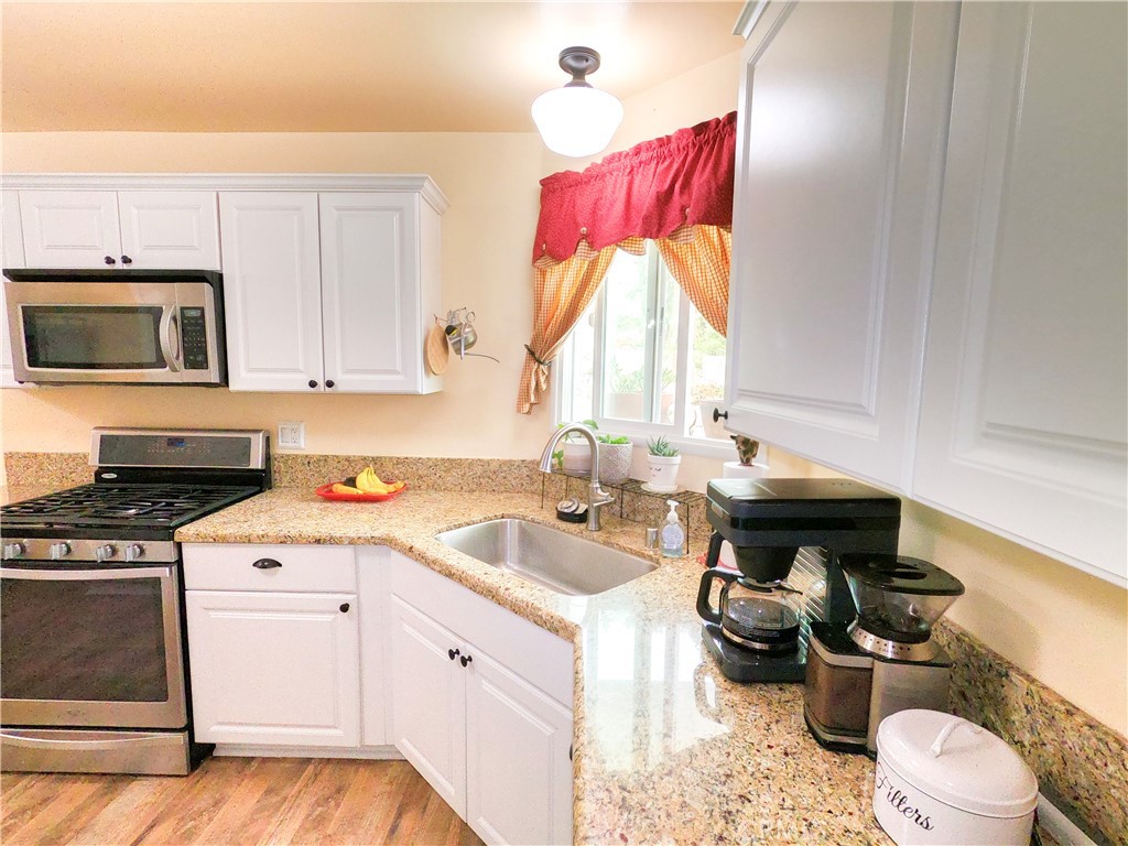 4757 Dundee Road Riverside, CA 92503 - Photo 10 of 26 a kitchen with a stove a sink and a microwave