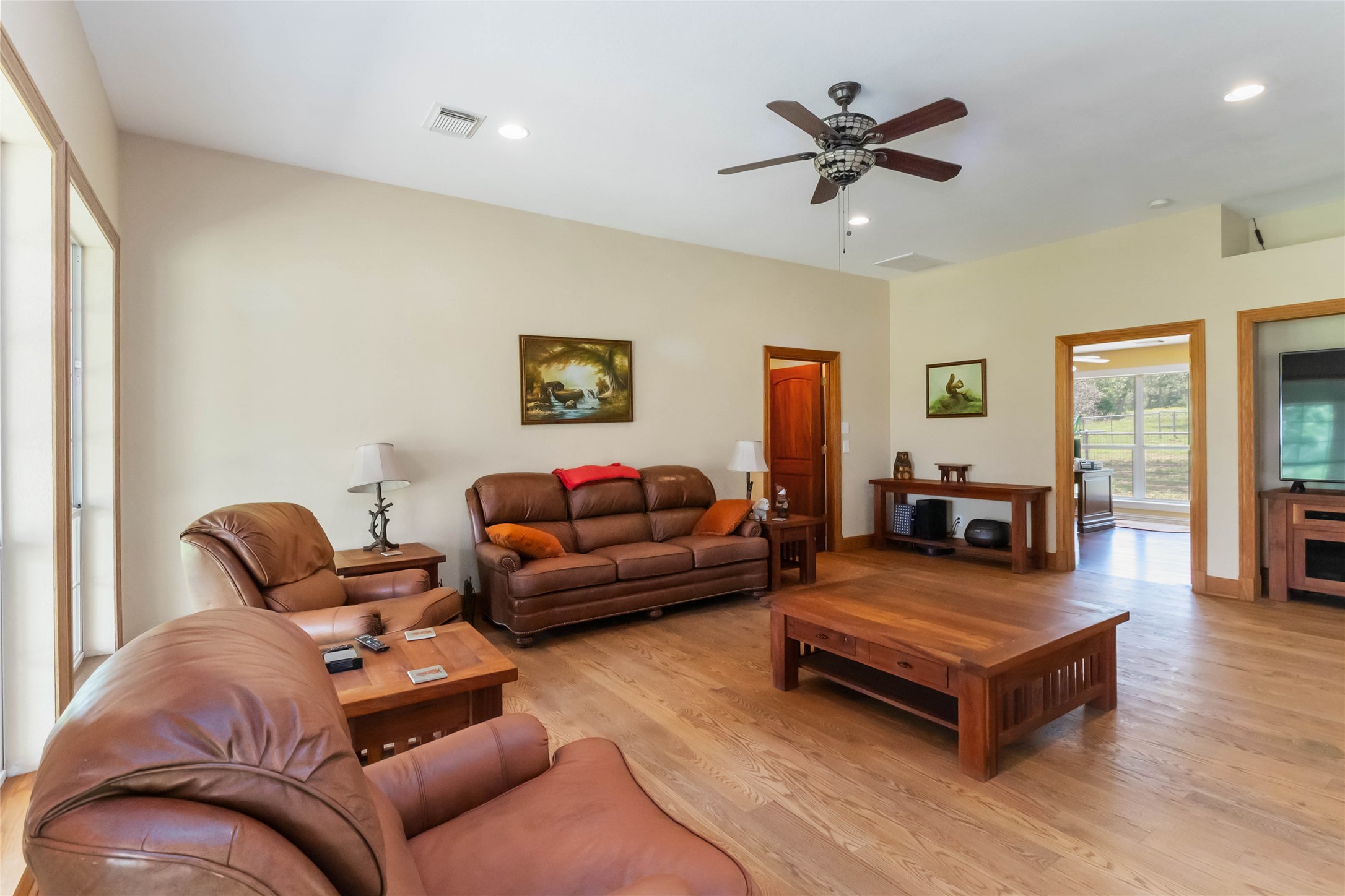 1208 Jeddo Road Rosanky, TX 78953 - Photo 5 of 40 Sun-kissed interiors welcome you home with warm hardwood floors and a ceiling fan for year-round comfort.