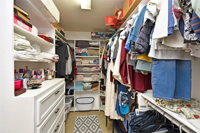 a view of walk in closet with clothes and shoes