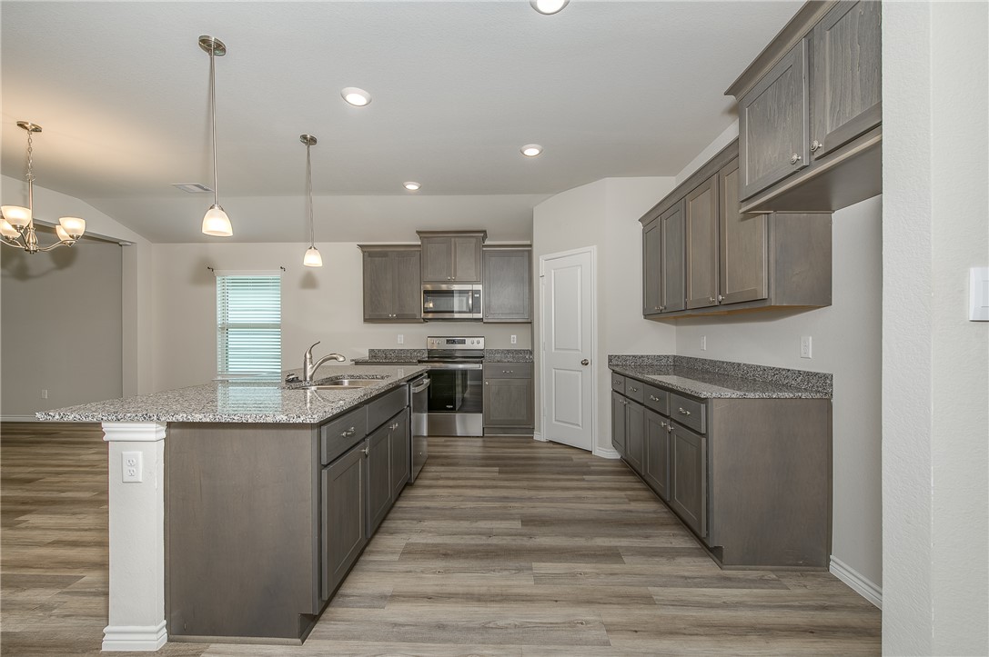 2166 Chief Street Bryan, TX 77807 - Photo 6 of 18 a large kitchen with stainless steel appliances kitchen island granite countertop a stove and a sink