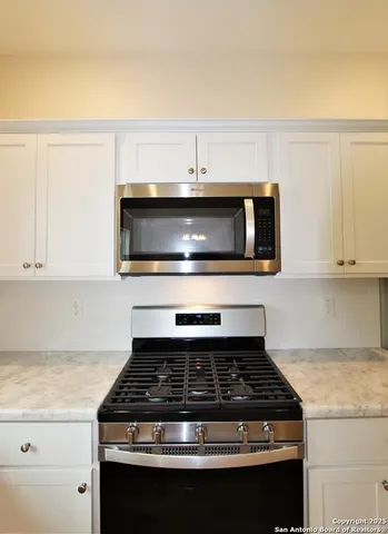 a stove top oven sitting inside of a kitchen