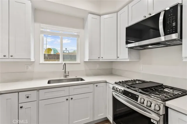a kitchen with white cabinets and appliances