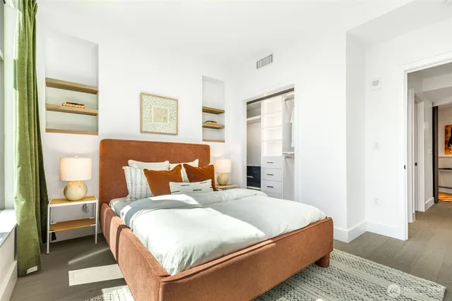 a bedroom with a bed and wooden floor