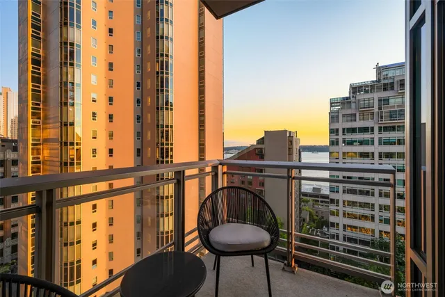 a view of balcony with a couple of chairs and a large tree