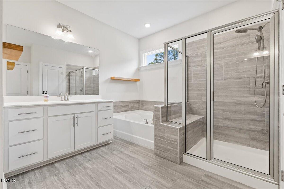 4937 Abundance Avenue Raleigh, NC 27616 - Photo 20 of 36 a spacious bathroom with a shower sink and mirror