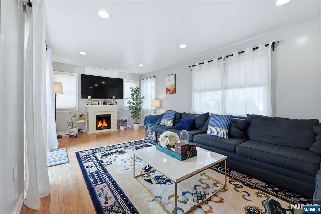 39 Voorhees Street Teaneck, NJ 07666 - Photo 14 of 47 a living room with furniture a fireplace and a flat screen tv