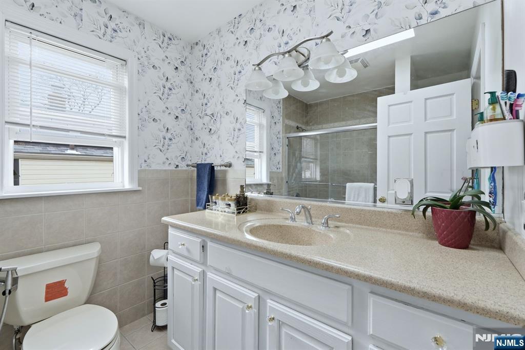 39 Voorhees Street Teaneck, NJ 07666 - Photo 23 of 47 a bathroom with a sink a mirror and a toilet