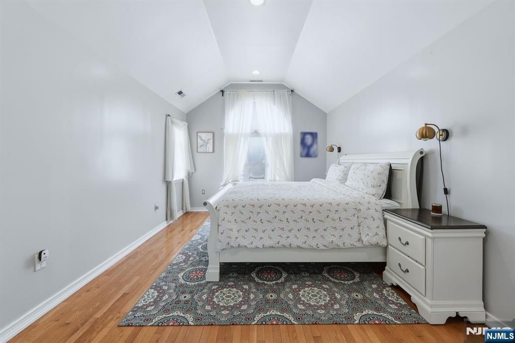 39 Voorhees Street Teaneck, NJ 07666 - Photo 25 of 47 a bedroom with a bed and a mirror