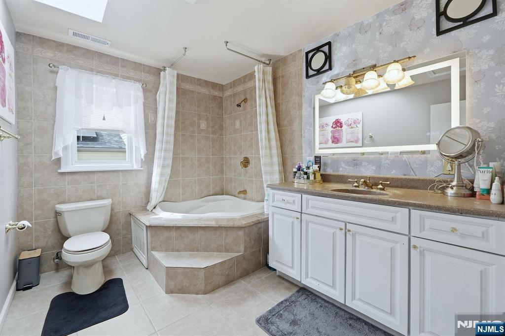 39 Voorhees Street Teaneck, NJ 07666 - Photo 30 of 47 a bathroom with a sink a toilet and a mirror