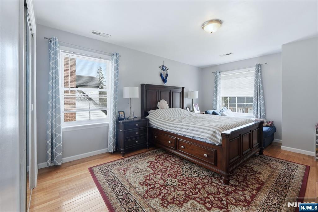 39 Voorhees Street Teaneck, NJ 07666 - Photo 32 of 47 a bedroom with a bed and wooden floor