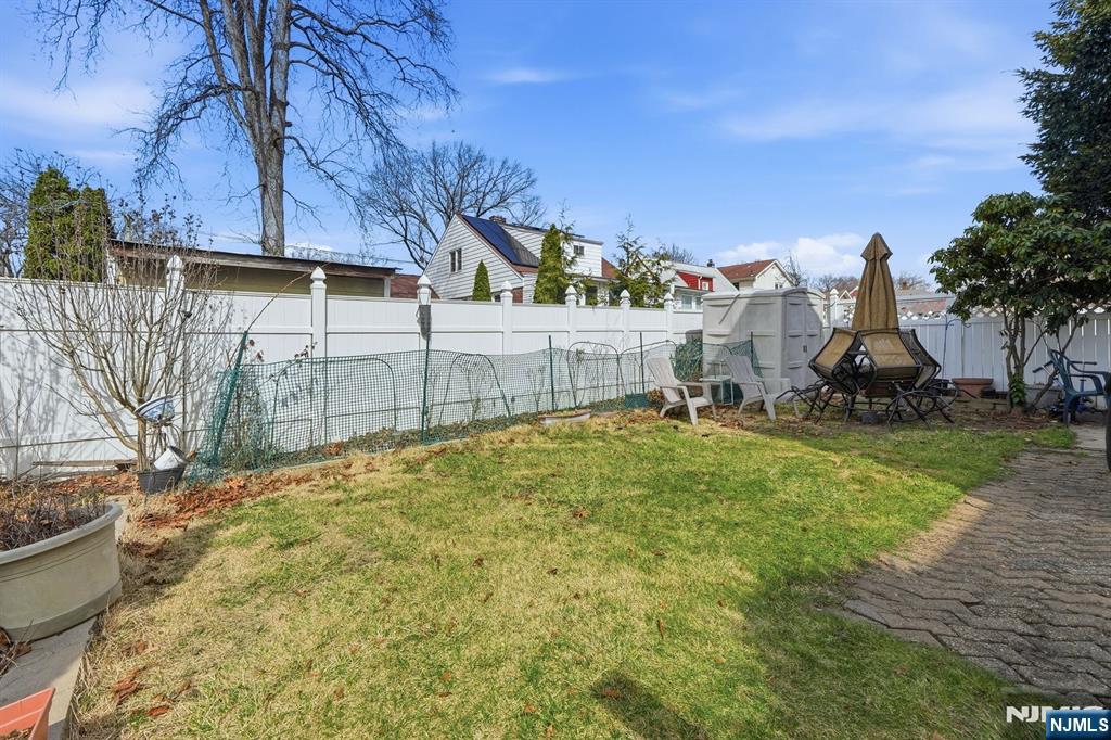 39 Voorhees Street Teaneck, NJ 07666 - Photo 5 of 47 a view of a garden with a slide and large trees