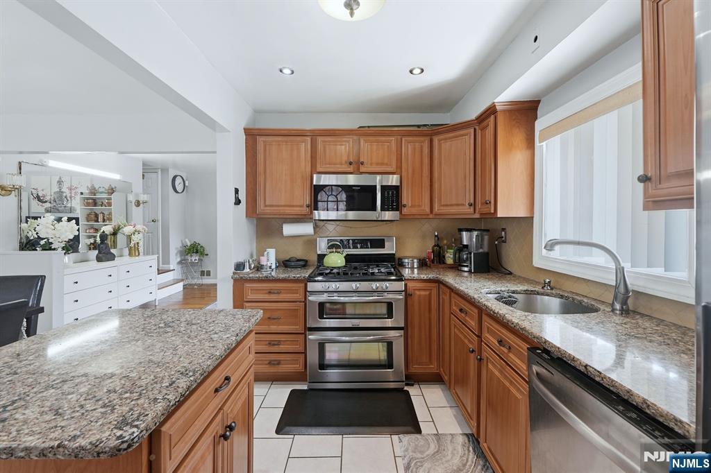 39 Voorhees Street Teaneck, NJ 07666 - Photo 9 of 47 a kitchen with stainless steel appliances granite countertop a stove a sink and a microwave