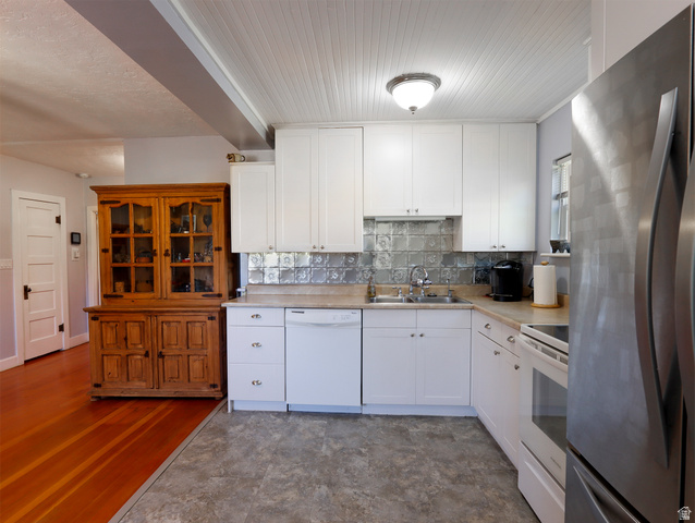 155 West Center Street Fillmore, UT 84631 - Photo 25 of 86 Kitchen featuring white cabinetry, textured backsplash, and contrasting flooring