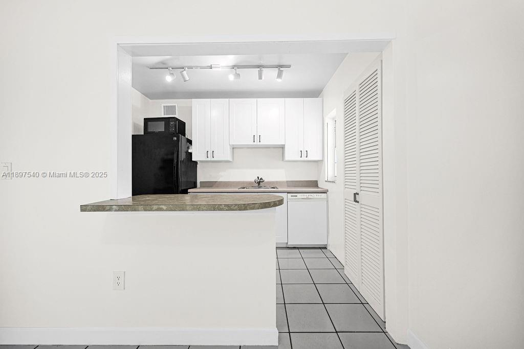 5960 Southwest 47th Street, Unit 1 Miami, FL 33155 - Photo 14 of 39 a kitchen with stainless steel appliances a refrigerator and cabinets