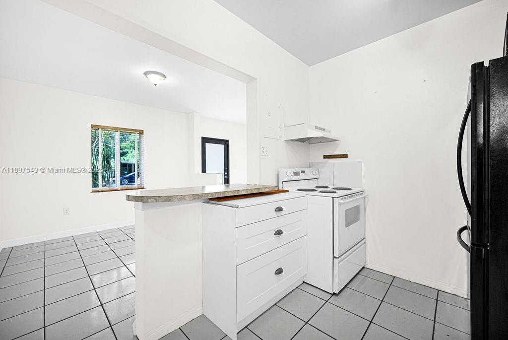 5960 Southwest 47th Street, Unit 1 Miami, FL 33155 - Photo 16 of 39 a kitchen with white cabinets and appliances