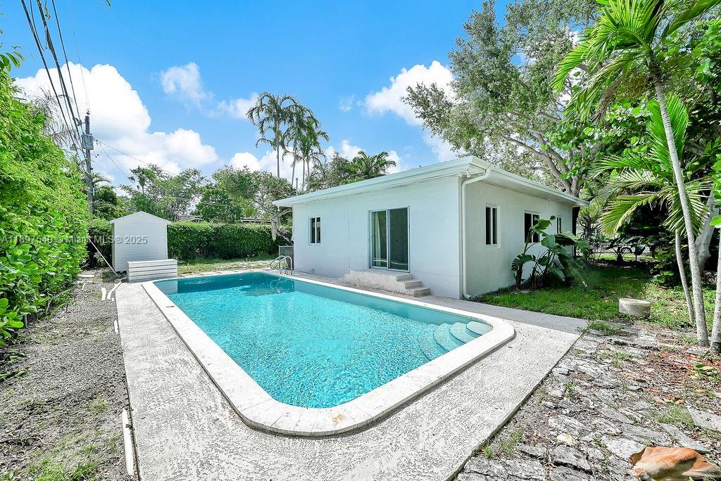 5960 Southwest 47th Street, Unit 1 Miami, FL 33155 - Photo 2 of 39 a view of a white house with a swimming pool and a yard