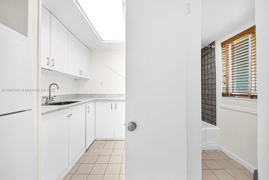 5960 Southwest 47th Street, Unit 1 Miami, FL 33155 - Photo 26 of 39 a kitchen with granite countertop white cabinets and white appliances