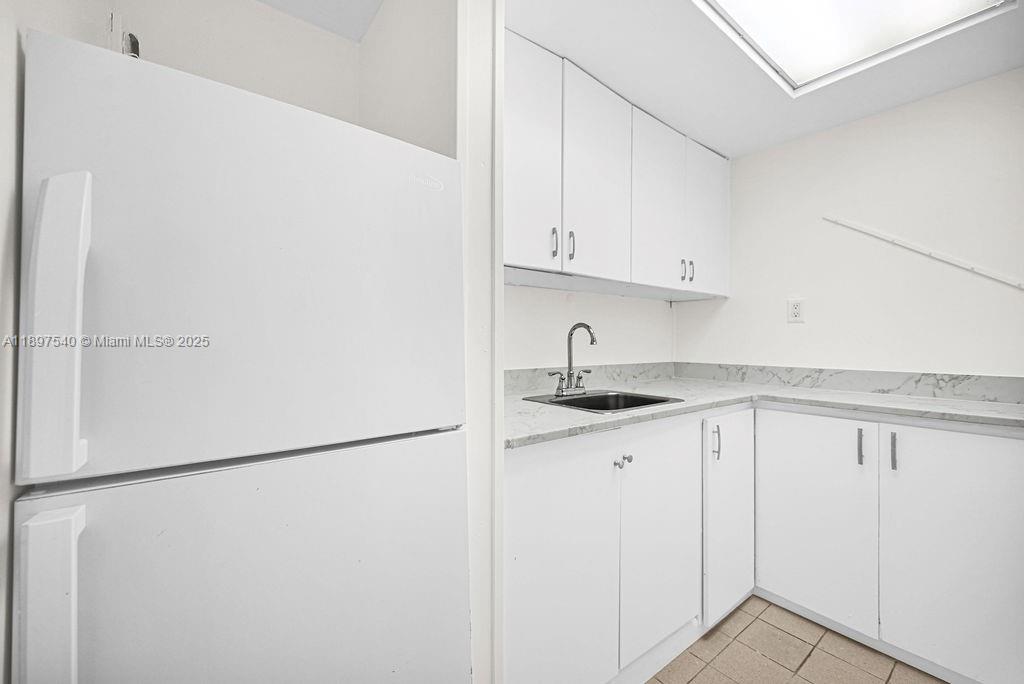 5960 Southwest 47th Street, Unit 1 Miami, FL 33155 - Photo 27 of 39 a kitchen with white cabinets and refrigerator