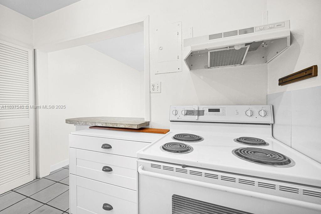 5960 Southwest 47th Street, Unit 1 Miami, FL 33155 - Photo 7 of 39 a white stove top oven sitting inside of a kitchen