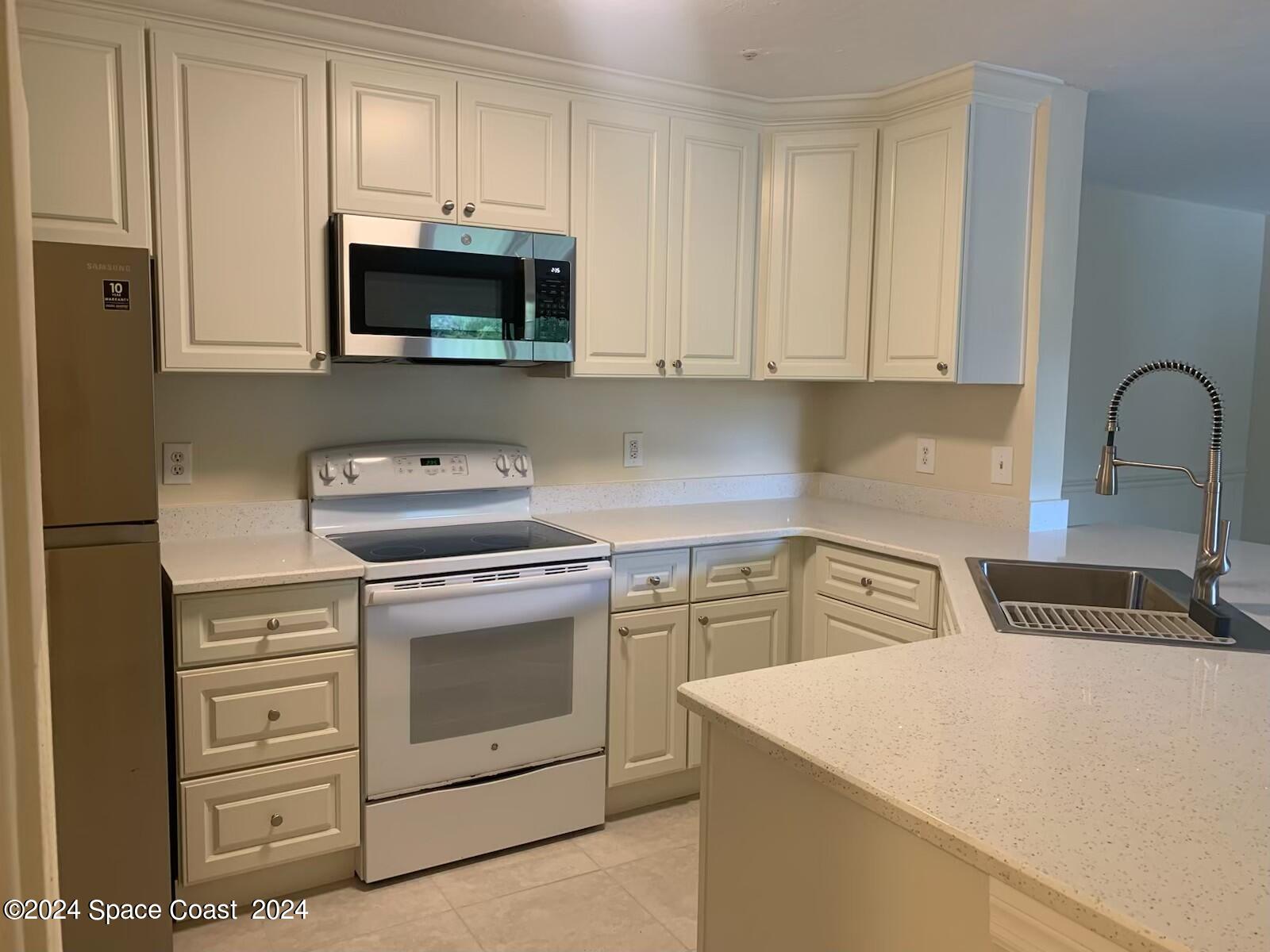7667 North Wickham Road, Unit 710 Melbourne, FL 32940 - Photo 4 of 23 a kitchen with cabinets appliances and a sink