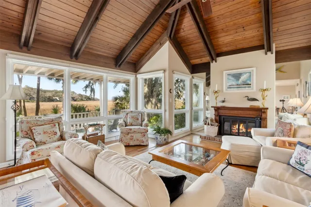 a living room with furniture large windows and a fireplace