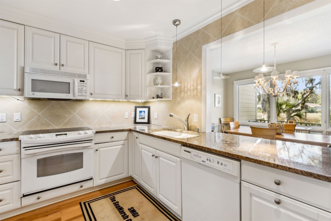 3417 Sea Marsh Road, Unit 3417 Fernandina Beach, FL 32034 - Photo 6 of 19 a kitchen with granite countertop white cabinets white appliances and sink
