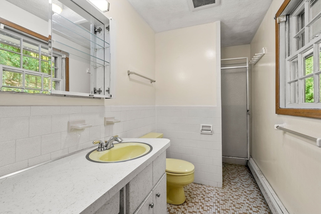16 Larnis Road Framingham, MA 01701 - Photo 10 of 17 a bathroom with a sink toilet a mirror and shower