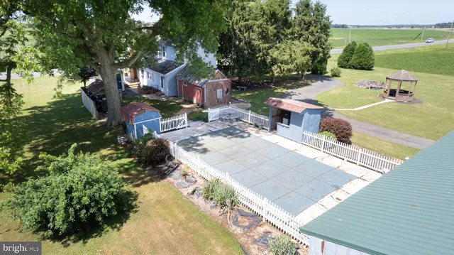 a view of a patio with table and chairs potted plants and large tree